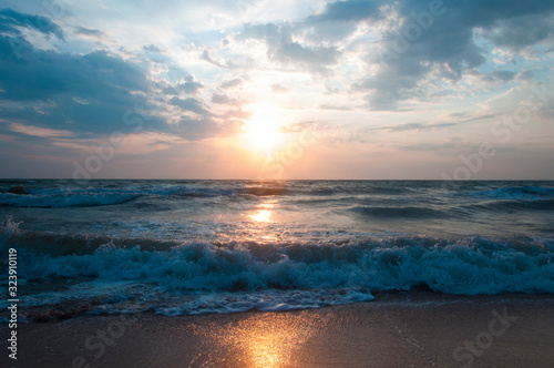 Beautiful beach with sand. Blue water. Sea wave with foam. Wonderful sunset. Gentle sunrise.