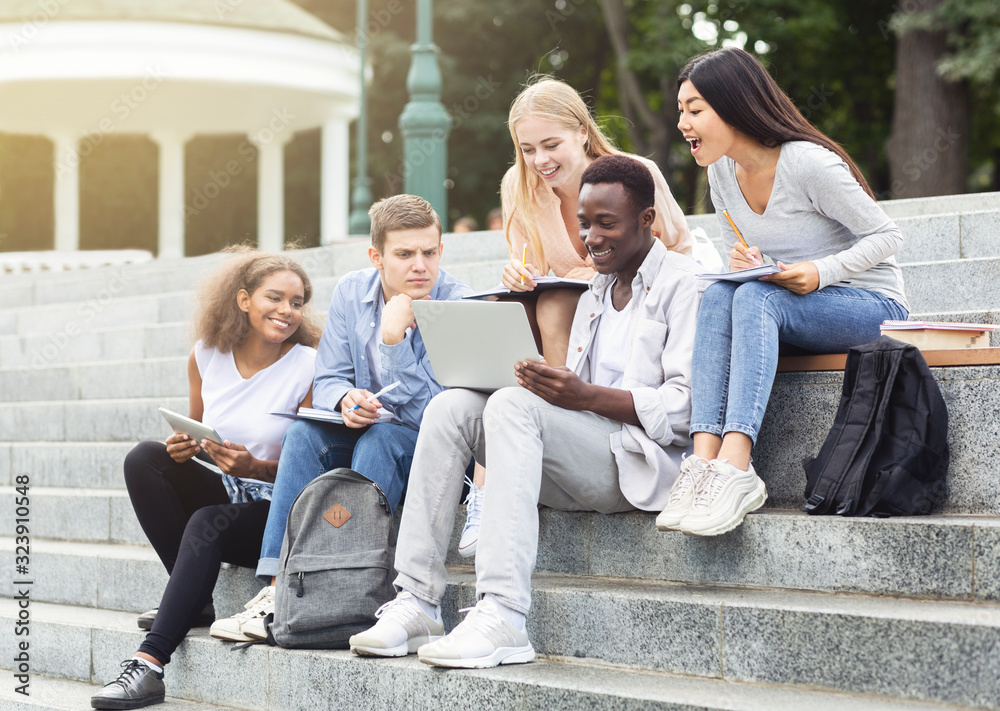 Group of international students studying together at park Group of international students studying together at park