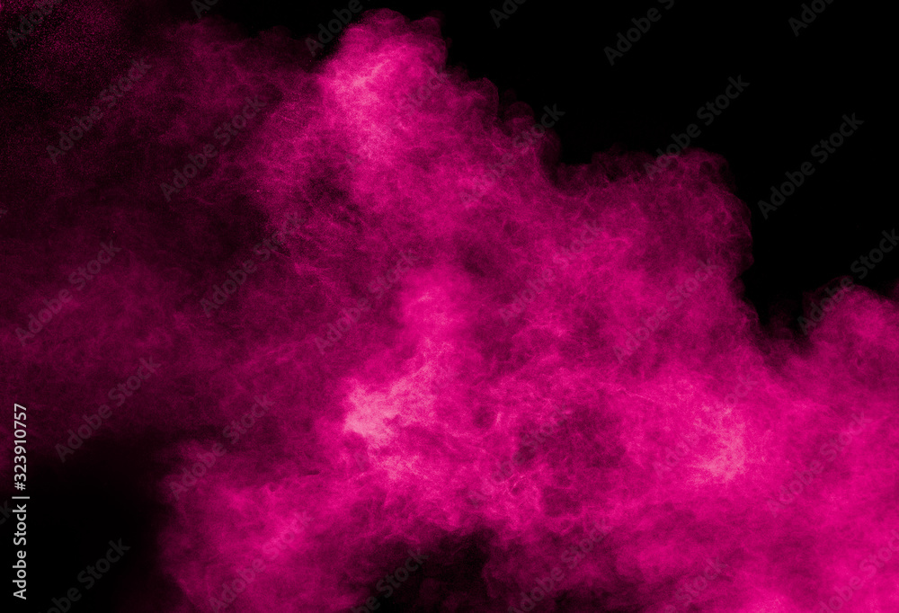 Abstract pink dust particles explosion on black background.Freeze motion of pink powder splash.