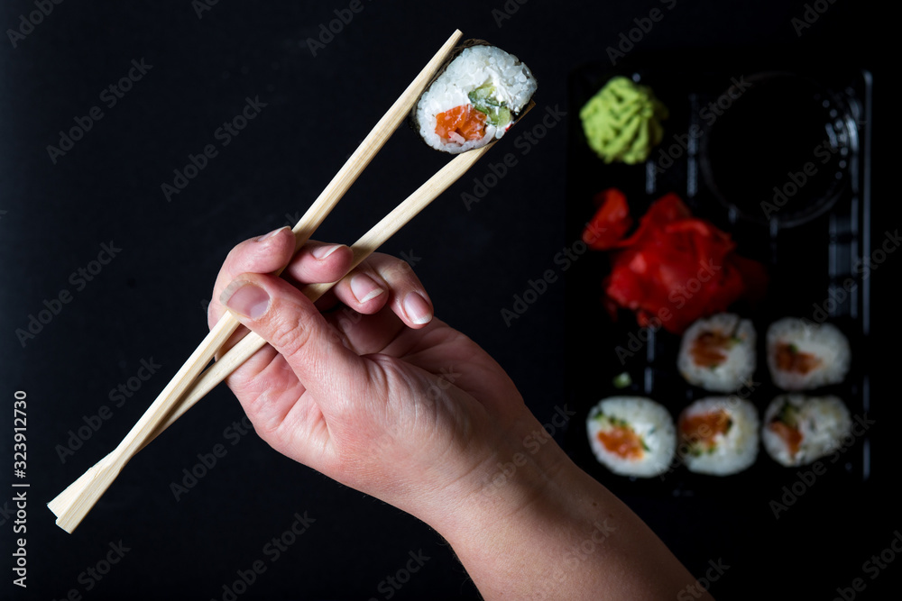 Hand hold with sticks roll of sushi Hand hold with sticks roll of sushi