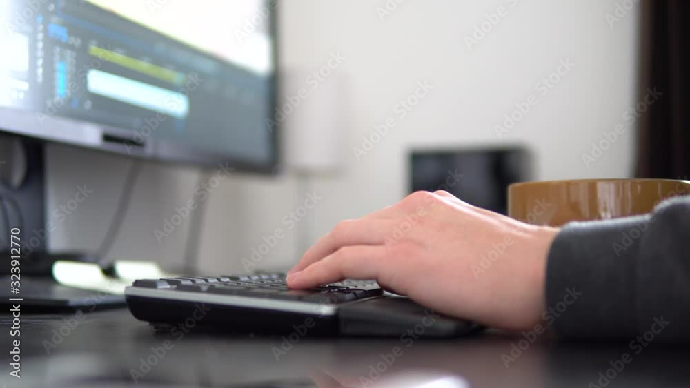 A time lapse of a person that works on a computer and types on a keyboard. Close, detailed view of persons hands and the keyboard. Man edits video in postproduction program. A time lapse of a person that works on a computer and types on a keyboard. Close, detailed view of persons hands and the keyboard. Man edits video in postproduction program.