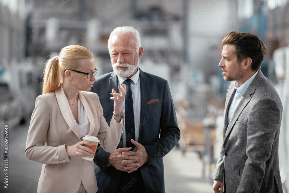 Colleagues working on project. Team of architects discussing business in factory. Colleagues working on project. Team of architects discussing business in factory.