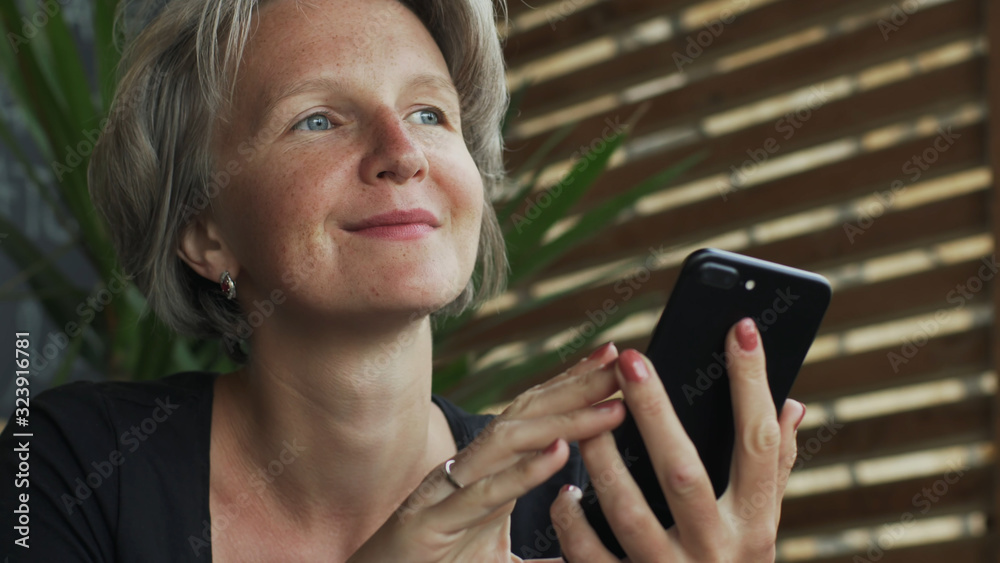 Fototapeta premium Close up attractive gray hair lady female using smartphone in cafe