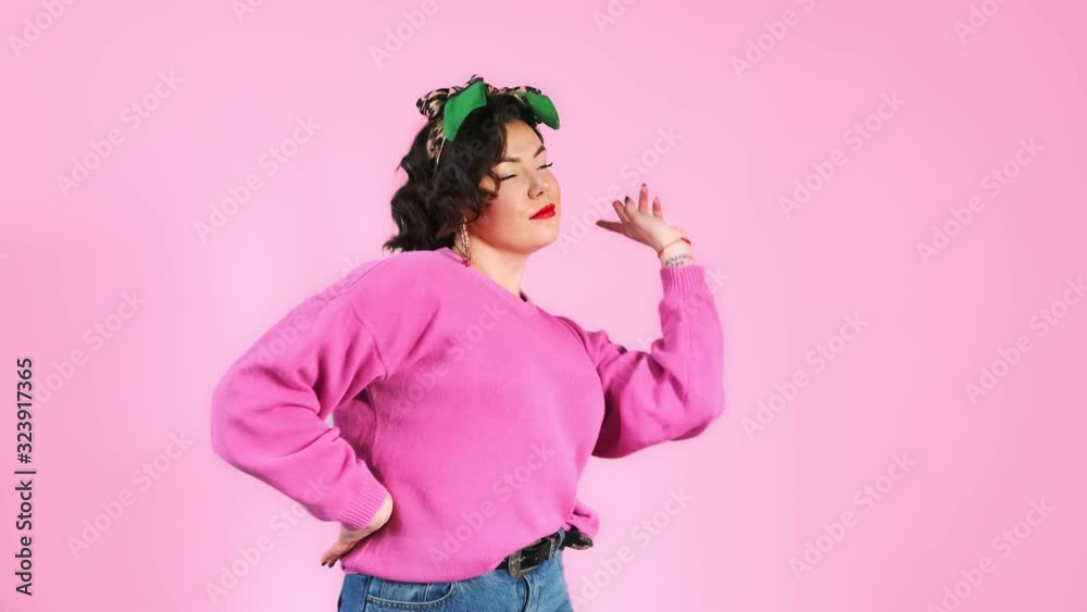 Portrait of a young hipster woman in glasses having fun and crazy dancing. Fooling around doing a weird dance and grimacing. Portrait of a young hipster woman in glasses having fun and crazy dancing. Fooling around doing a weird dance and grimacing.