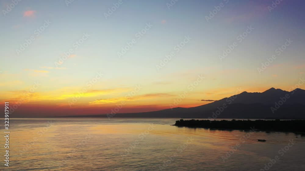 fantastic colors of a tropical sunset. Mountain island on the horizon. Misty evening aerial cinematic fantastic colors of a tropical sunset. Mountain island on the horizon. Misty evening aerial cinematic