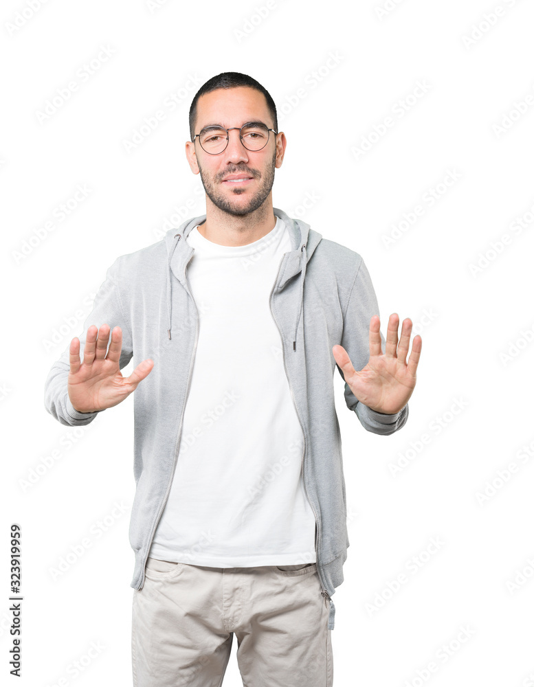 Friendly young man doing a gesture of keep calm Friendly young man doing a gesture of keep calm
