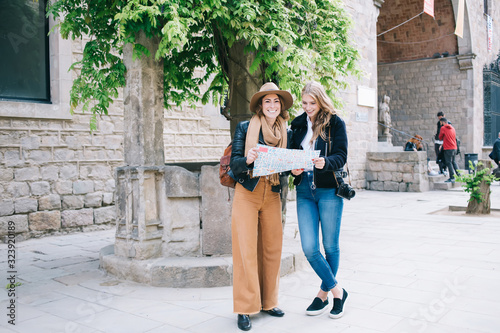 Young female tourists consulting city map