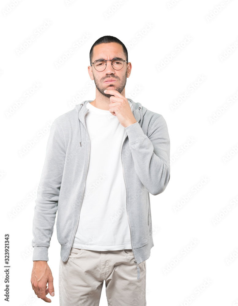 Concerned young man making a gesture of doubt Concerned young man making a gesture of doubt