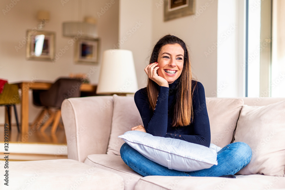 Beautiful smiling woman relaxing on the couch at home Beautiful smiling woman relaxing on the couch at home