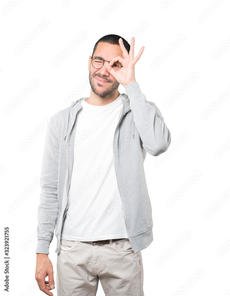 Happy young man using his hands like a binoculars Happy young man using his hands like a binoculars