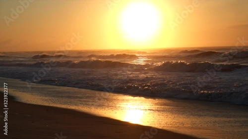 Slow motion clip of sunrise at beach with waves crashing on shore. Long Island New York. photo