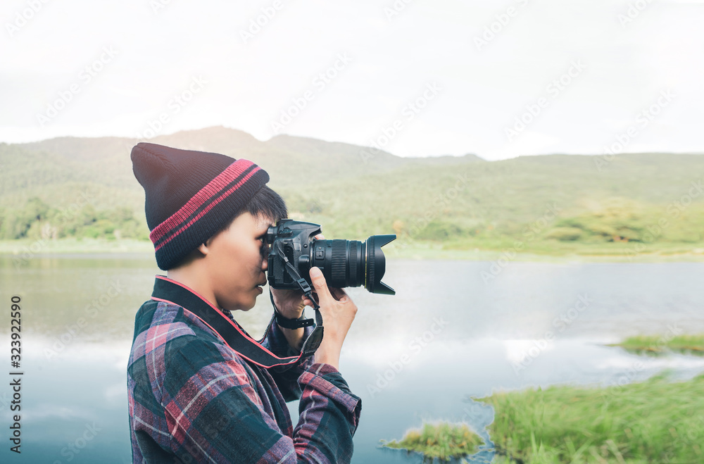 The Asian photographer using Camera DSLR, Digital Single Lens Reflex takes a photo mountain  river of  landscape. Traveling Concept. Hiker concept.