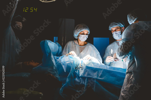 The senior surgeon in the operating room, where the patient is waiting for him, and he begins the operation. Real Modern Hospital with Authentic Equipment.