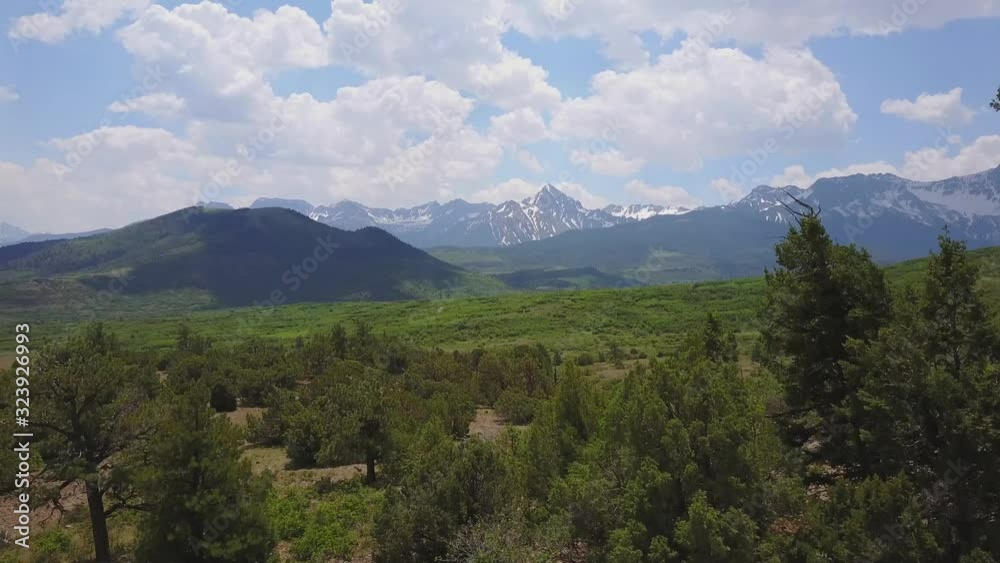 Ascending aerial revealing lush, green plateau and mountains beyond