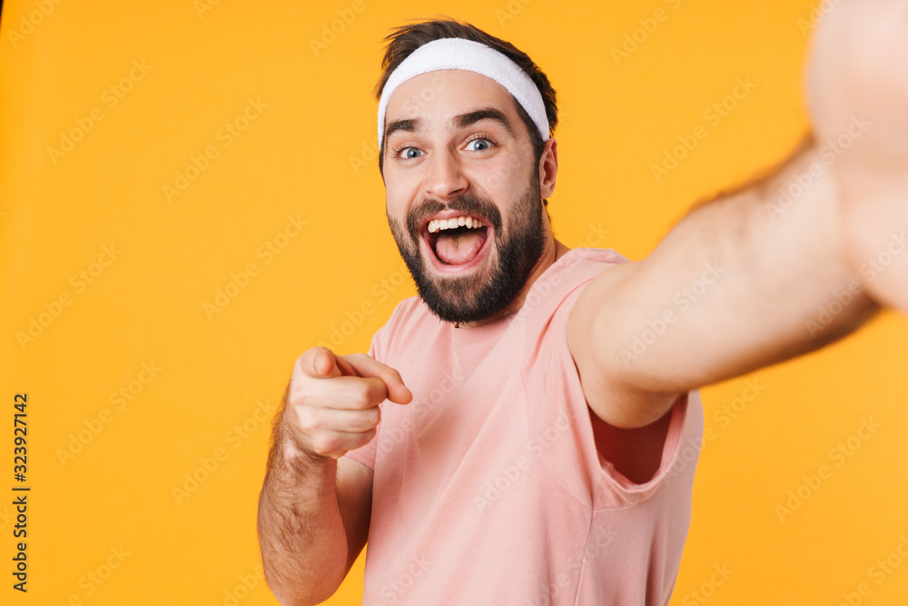 Image of athletic young man in t-shirt smiling and taking selfie photo Image of athletic young man in t-shirt smiling and taking selfie photo