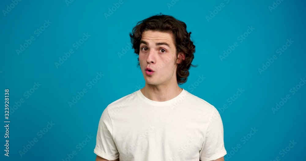 Front view of handsome young man shaking head and saying no isolated on blue background Front view of handsome young man shaking head and saying no isolated on blue background