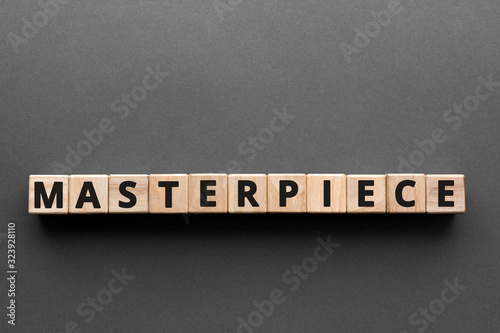Masterpiece - words from wooden blocks with letters, excellent quality masterpiece concept, top view gray background