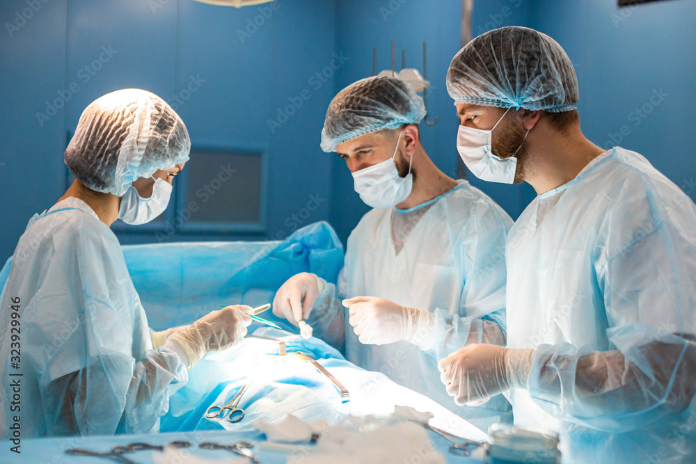 An international team of doctors performs a complex surgical operation on a patient under anesthesia. Modern operating room and experienced surgeons save lives