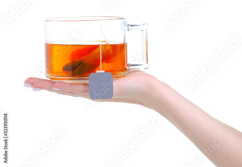 glglass cup mug of tea with teabag in hand on white background isolation