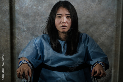 Fotografia young crazy and mentally insane Asian woman restrained in wheelchair at mental h