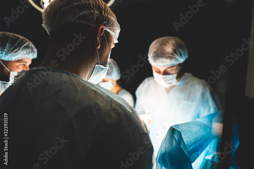An international team of doctors performs a complex surgical operation on a patient under anesthesia. Modern operating room and experienced surgeons save lives