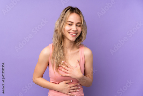 Teenager Russian girl isolated on purple background smiling a lot