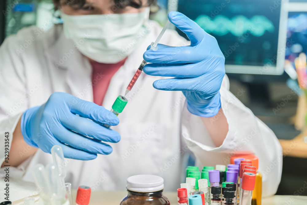Blood test tube in Medical Scientist hand with syringe mixed specimen in Laboratory room at hospital, blood test tube for analysis for diagnosis illness results