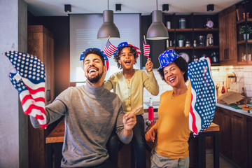 Family in living room on fourth of July with flags smiling