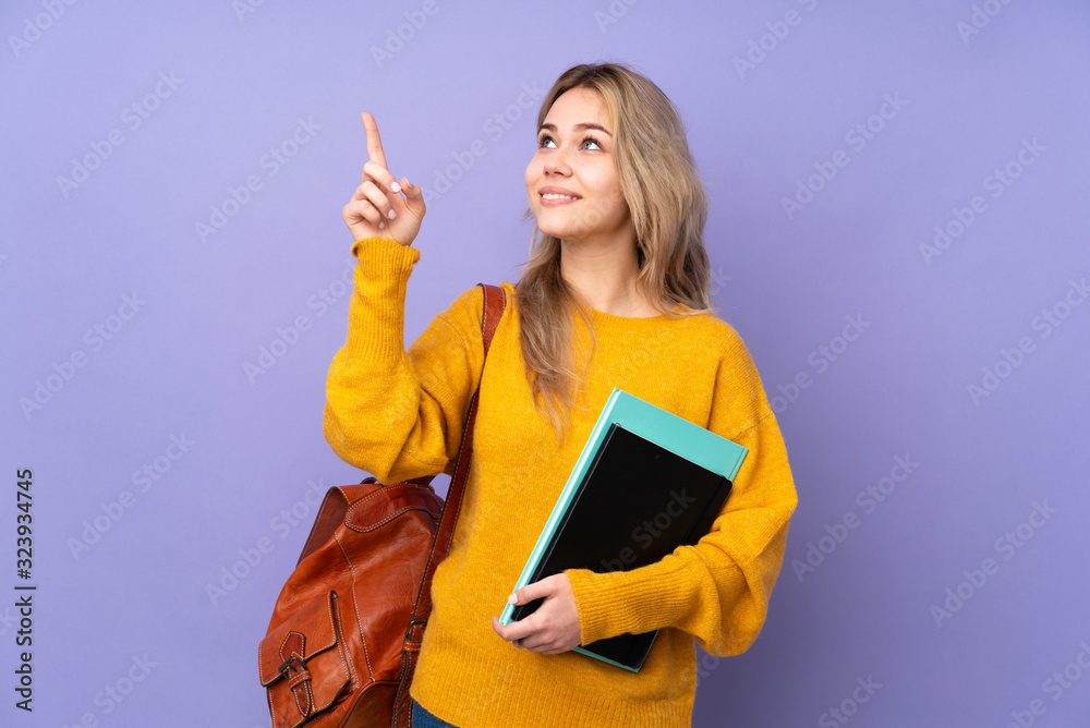 Teenager Russian student girl isolated on purple background pointing with the index finger a great idea - obrazy, fototapety, plakaty 