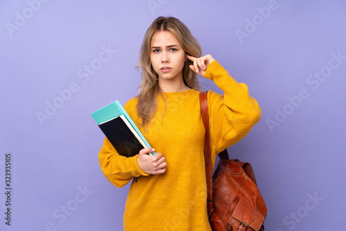 Teenager Russian student girl isolated on purple background frustrated and covering ears