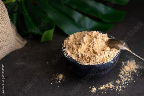 Gofio, Canarian flour made from different roasted grains on concrete background with tropical leafe. This is important ingredient of many dish of Canary Islands Cuisine. photo