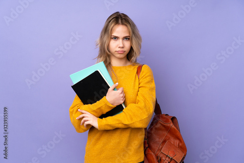 Teenager Russian student girl isolated on purple background feeling upset