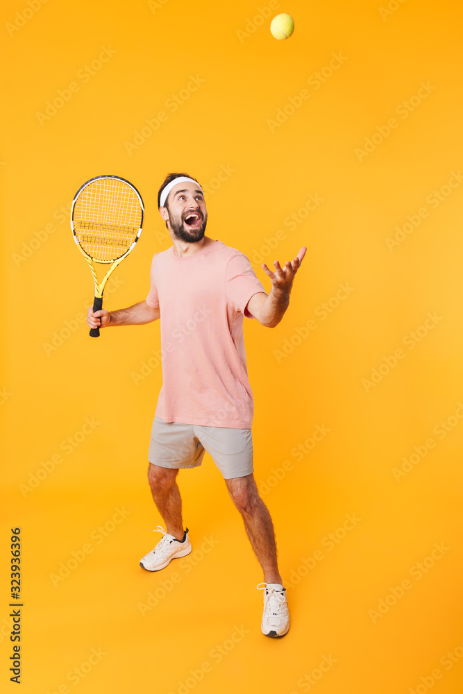 Image of athletic young man holding rackets while playing tennis
