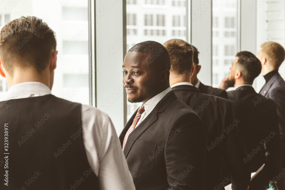 Silhouettes of people against the window. A team of young businessmen working and communicating together in an office. Corporate businessteam and manager in a meeting. Silhouettes of people against the window. A team of young businessmen working and communicating together in an office. Corporate businessteam and manager in a meeting.