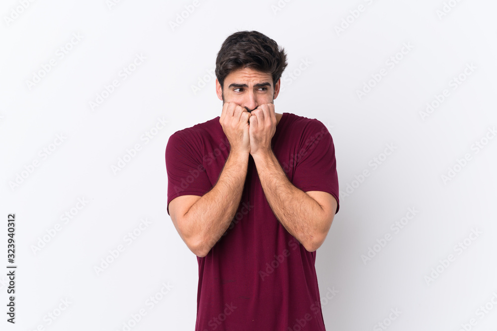Young handsome man with beard over isolated white background nervous and scared putting hands to mouth Young handsome man with beard over isolated white background nervous and scared putting hands to mouth