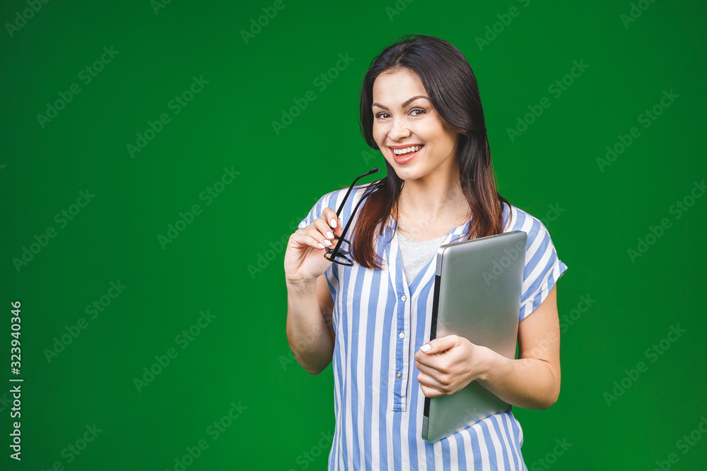 Young happy smiling woman in casual clothes holding laptop isolated over green background. Young happy smiling woman in casual clothes holding laptop isolated over green background.
