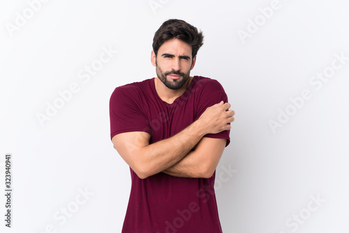 Young handsome man with beard over isolated white background freezing
