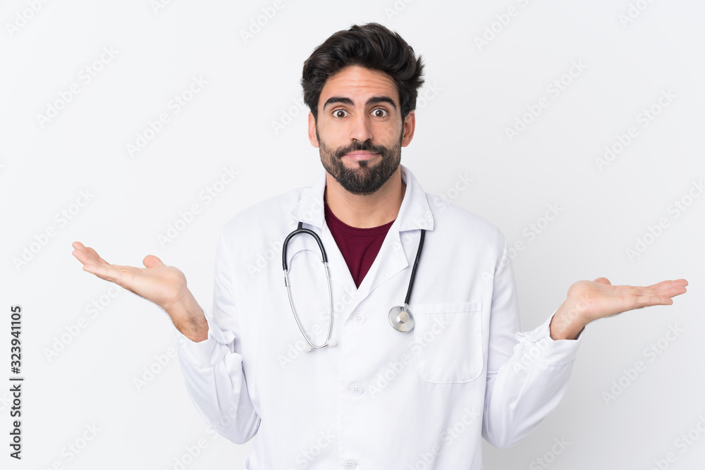 Young handsome man with beard over isolated white background wearing a doctor gown and having doubts Young handsome man with beard over isolated white background wearing a doctor gown and having doubts