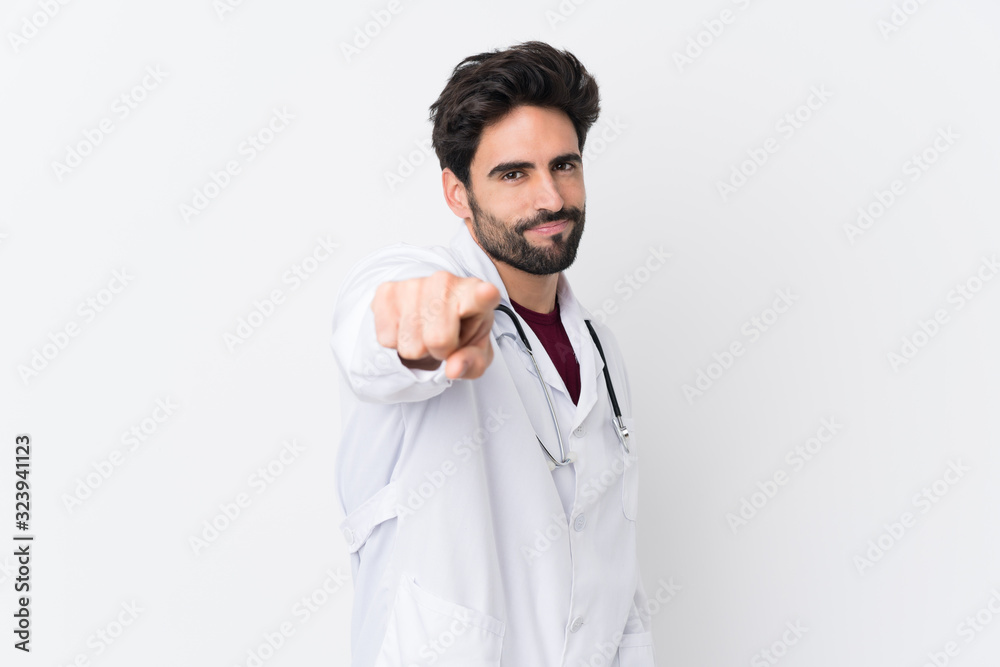 Young handsome man with beard over isolated white background wearing a doctor gown and pointing to the front Young handsome man with beard over isolated white background wearing a doctor gown and pointing to the front