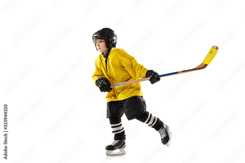 Little hockey player with the stick on ice court and white studio background. Sportsboy wearing equipment and helmet practicing, training. Concept of sport, healthy lifestyle, motion, movement, action Little hockey player with the stick on ice court and white studio background. Sportsboy wearing equipment and helmet practicing, training. Concept of sport, healthy lifestyle, motion, movement, action