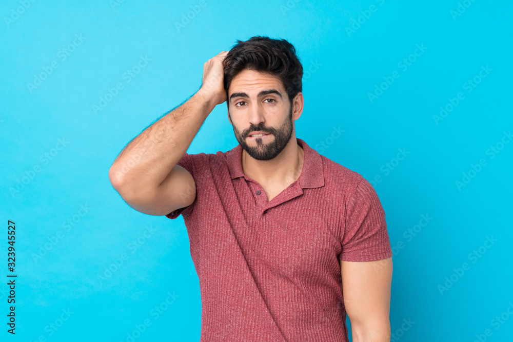 Young handsome man with beard over isolated blue background with an expression of frustration and not understanding Young handsome man with beard over isolated blue background with an expression of frustration and not understanding