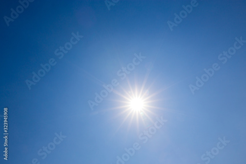 Shining sun on clear blue sky. lens flare of sunlight on blue sky background. Bright sun on blue sky.