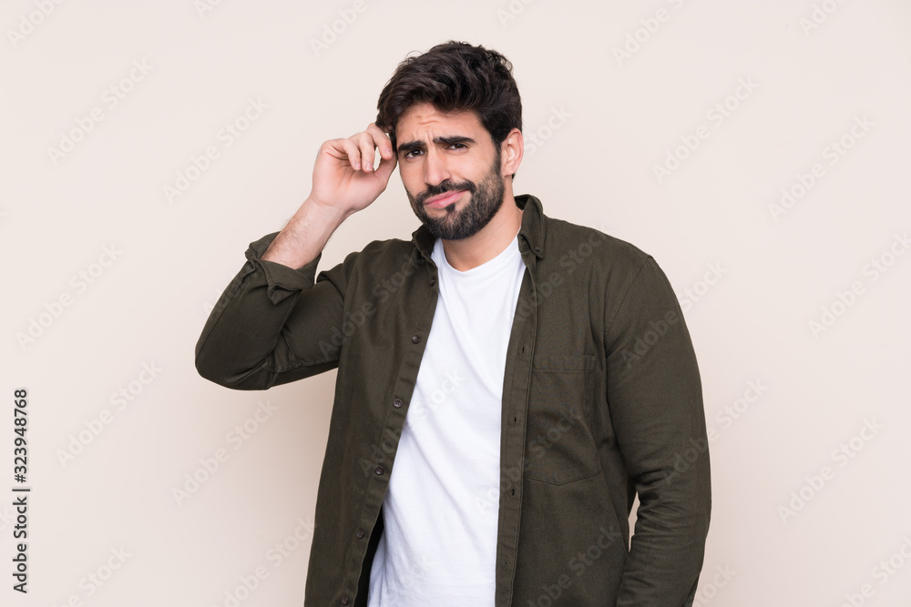 Young handsome man with beard over isolated background having doubts Young handsome man with beard over isolated background having doubts