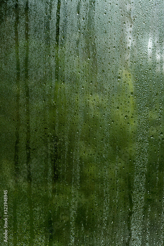 condensation droplets in a window glass, green nature abstract background
