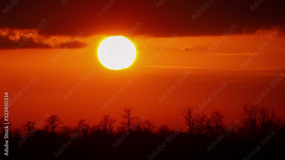Sunset Time with Rain Clouds and Bright Sun Disk in Orange Sky. Time Lapse Dusk Sunset Time with Rain Clouds and Bright Sun Disk in Orange Sky. Time Lapse Dusk