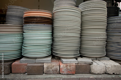 side view of a stack of decorative ceramic plates in the glassware shop. 