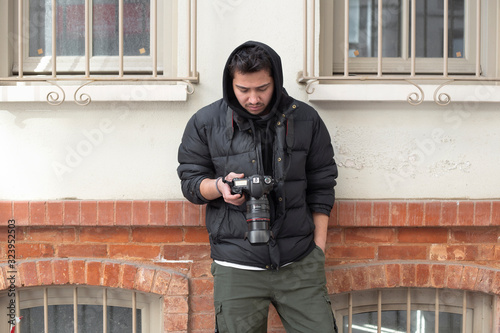 Young photographer looking at his photos on the street