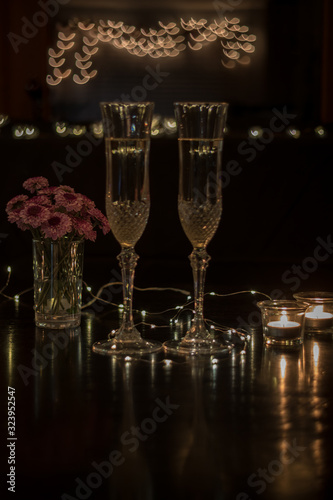 Champagne and pink flowers on dark table for romantic dinner date night heart bokeh