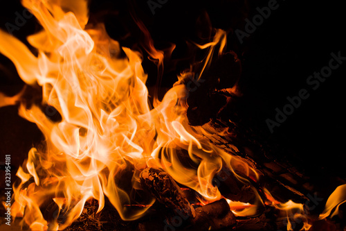 Orange flames on a black background, closeup. Texture of a fiery flame