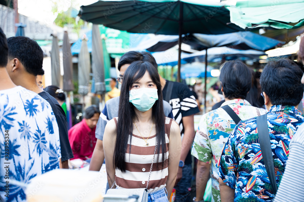 A woman wearing a mask To prevent corona virus and prevent pm 2.5 pollution In a market with a lot of people